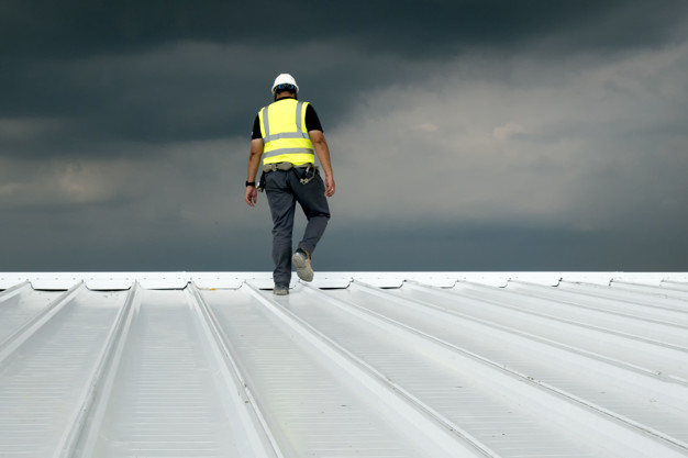 pracownik budowlany na dachu